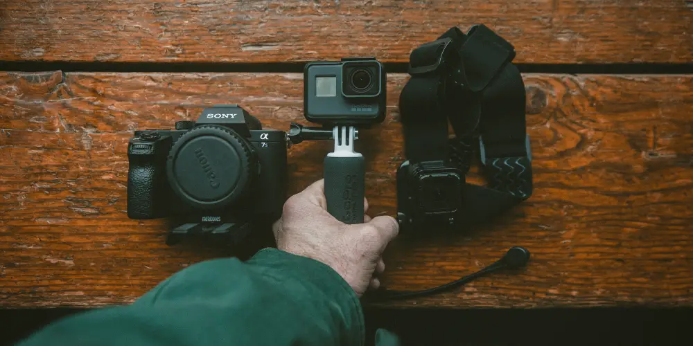 a man's hand holding a mini camera