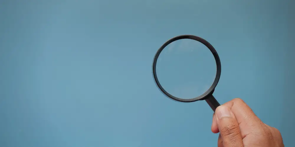 a man's hand holding a magnifying glass