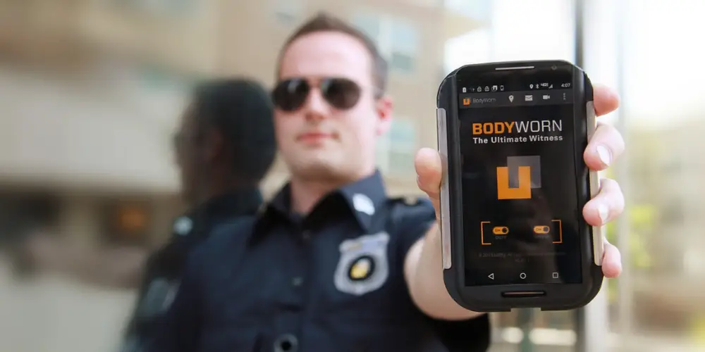 a male police officer showing his body camera