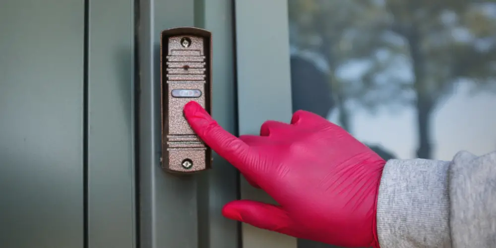 a hand ringing a doorbell