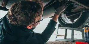 a man fixing the car's undercarriage