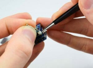 a hand assembling a microchip