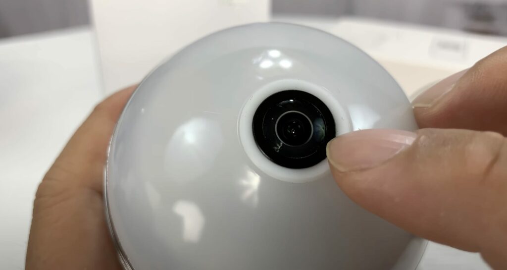 A person checking the hidden camera in a LED light bulb